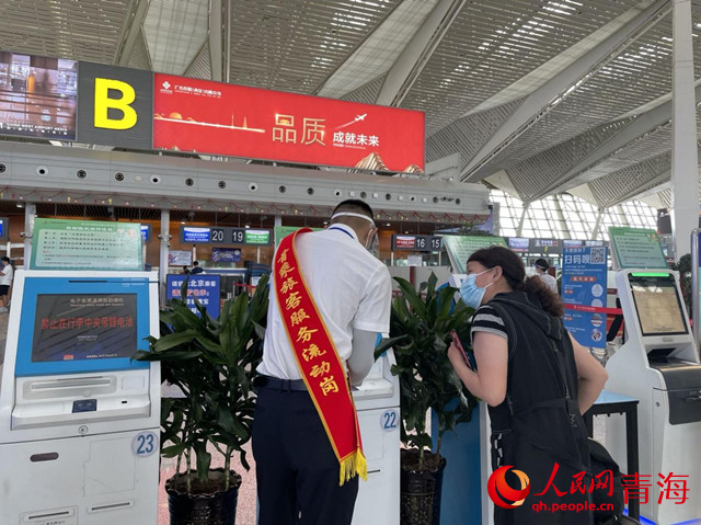 首乘旅客服務(wù)流動(dòng)崗工作人員為旅客提供幫助。人民網(wǎng) 況玉攝