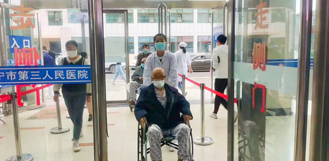 西寧市第三人民醫(yī)院陪檢配送中心工作人員陪同患者入院。青海省衛(wèi)生健康委員會供圖