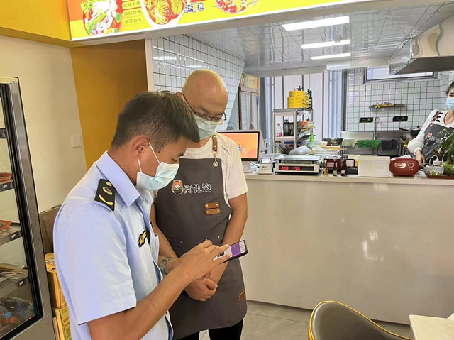 城北區(qū)市場監(jiān)督管理局工作人員對飯店進行檢查。城北區(qū)委宣傳部供圖