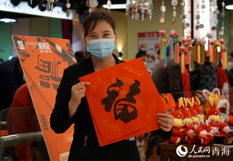 市民領(lǐng)取到義寫的春聯(lián)。人民網(wǎng) 況玉攝