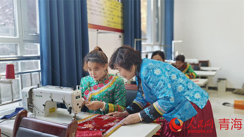 文青花正在指導繡娘做刺繡。人民網記者 張莉萍攝