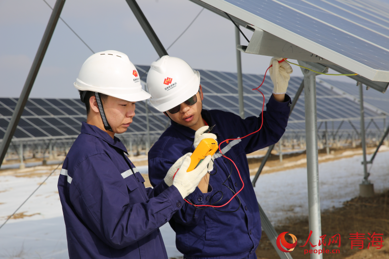 塔拉灘的光伏光熱園區(qū)內(nèi)，工作人員正在測(cè)量光伏組串開路電壓及電流數(shù)據(jù)。人民網(wǎng) 馬可欣攝