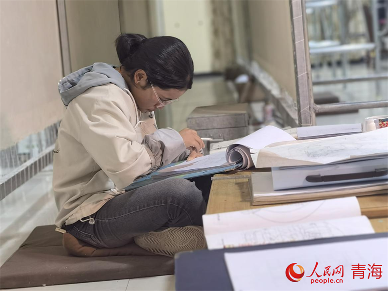 正在學(xué)習(xí)畫底稿的尕讓旺姆。人民網(wǎng) 陳明菊攝