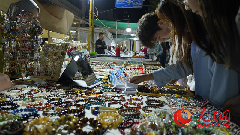 游客在夜市選購。人民網(wǎng)記者 甘海瓊攝