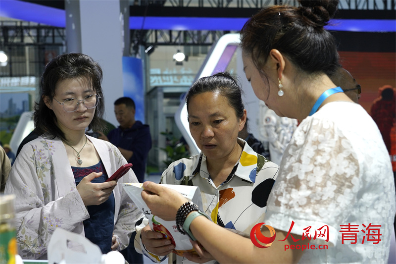 游客咨詢(xún)購(gòu)買(mǎi)展館內(nèi)相關(guān)商品。人民網(wǎng)記者 甘海瓊攝