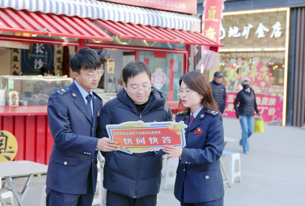 稅務(wù)干部為商戶工作人員講解憲法知識。賈敬波攝