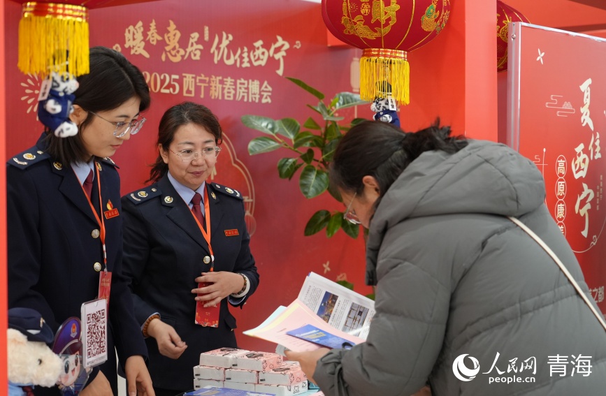 稅務(wù)部門工作人員向購房群眾介紹稅費政策。人民網(wǎng)記者 甘海瓊攝