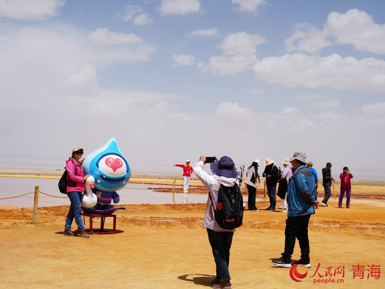 游客與艾肯泉文創(chuàng)玩偶合影。人民網(wǎng) 況玉攝