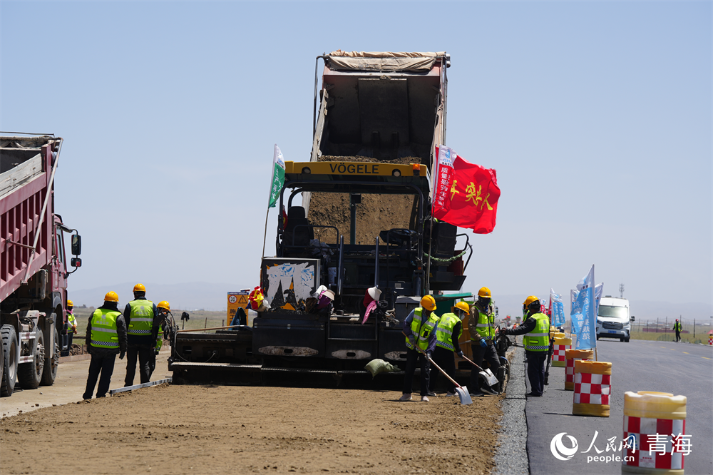 工人正在進行路面攤鋪工作。人民網(wǎng) 馬可欣攝