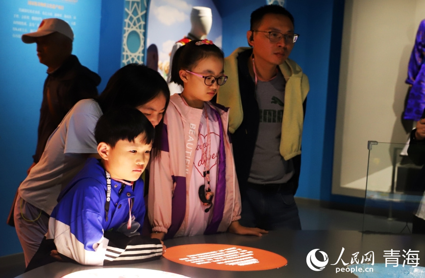 家長(zhǎng)帶著小朋友參觀文物。實(shí)習(xí)生 張秀青攝