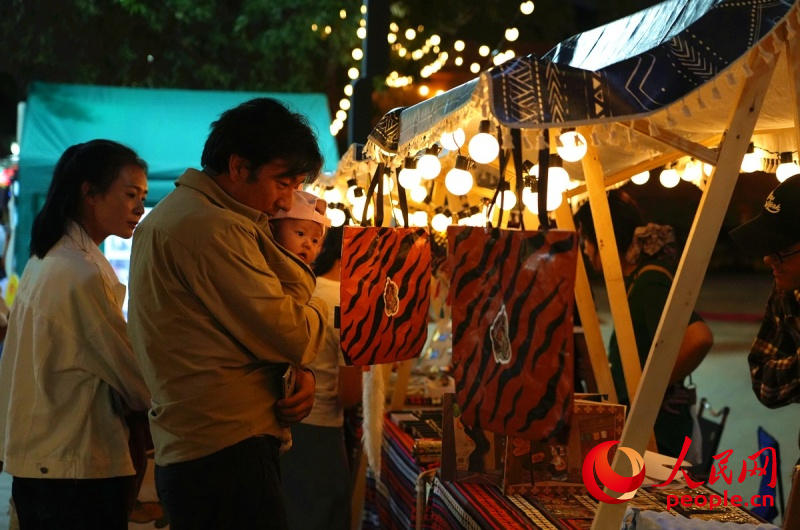 游客在同仁唐卡小鎮(zhèn)文創(chuàng)攤位前駐足。人民網(wǎng)記者 楊啟紅攝